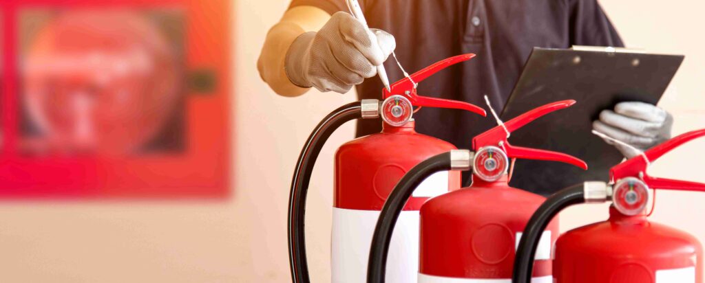 Mitarbeiter in einem Seminarraum mit Feuerlöschern und Brandschutz Checklisten