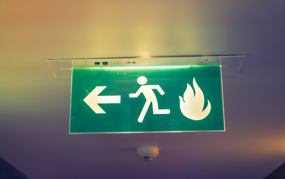 Leuchtendes Fluchtweg-Schild mit Brand-Symbol in einem Berliner Gebäude